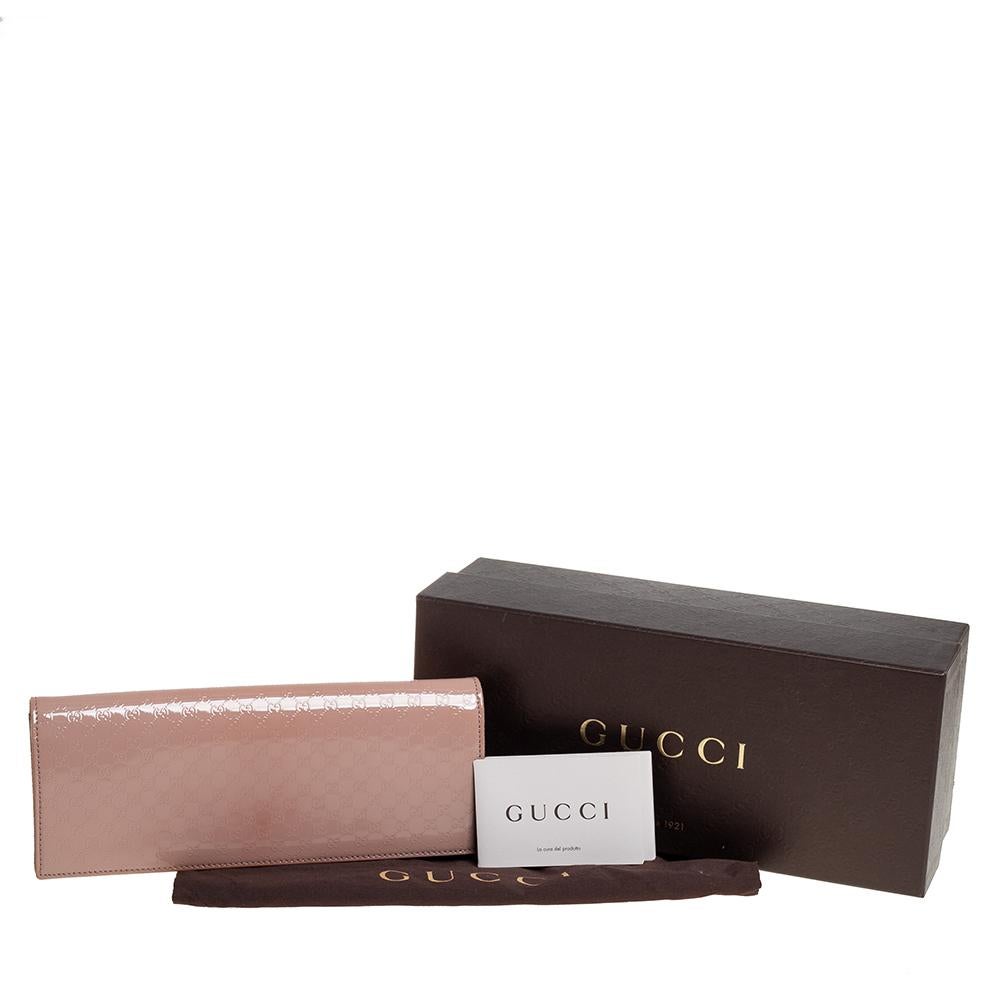This Gucci clutch is a must-have in your wardrobe to finish your look. This Broadway clutch is crafted from patent leather with micro-Guccissima pattern embossment and features gold-tone hardware. The flap closure with concealed magnetic fastening