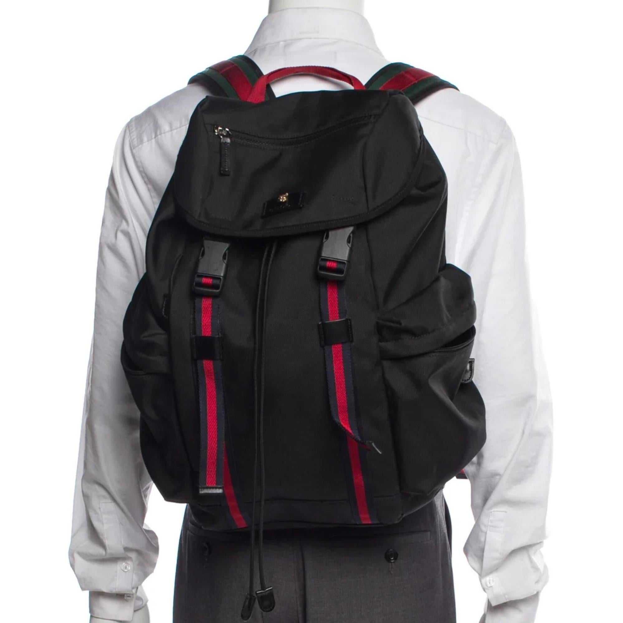Gucci backpack. Black canvas. Web accent. Tonal hardware. Flat handle & dual adjustable shoulder straps. Three exterior pockets. Nylon lining & three interior pockets. Buckle. Closure at front.

Color: Black
Material: Synthetic
Model No.: