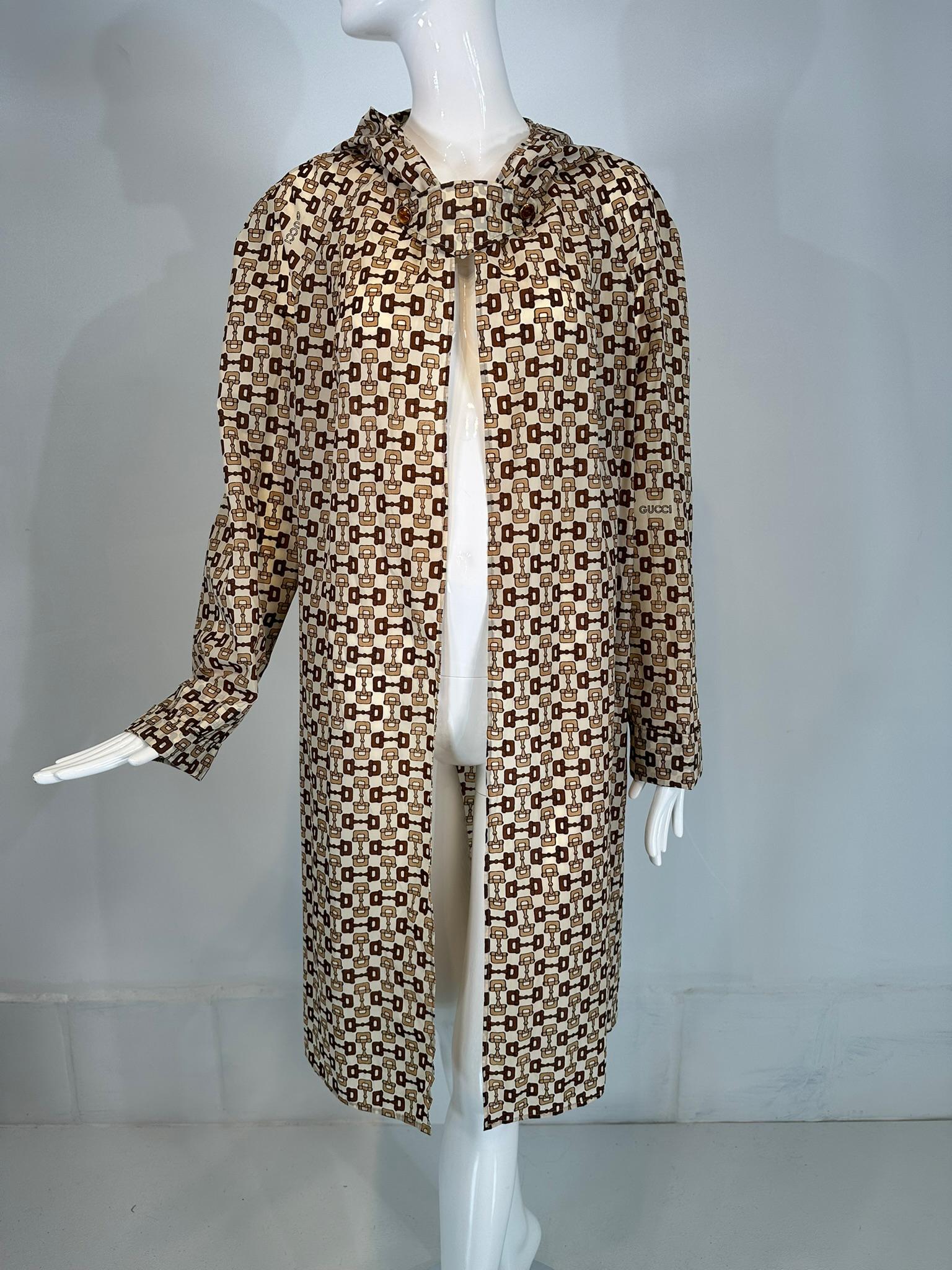 Gucci nylon travel hooded rain coat & carry pouch vintage from the 1960s. Novelty raincoat is lightweight Gucci logo fabric, it packs quickly into the original snap closure pouch. Lightweight nylon coat is open front with Gucci logo buttons on