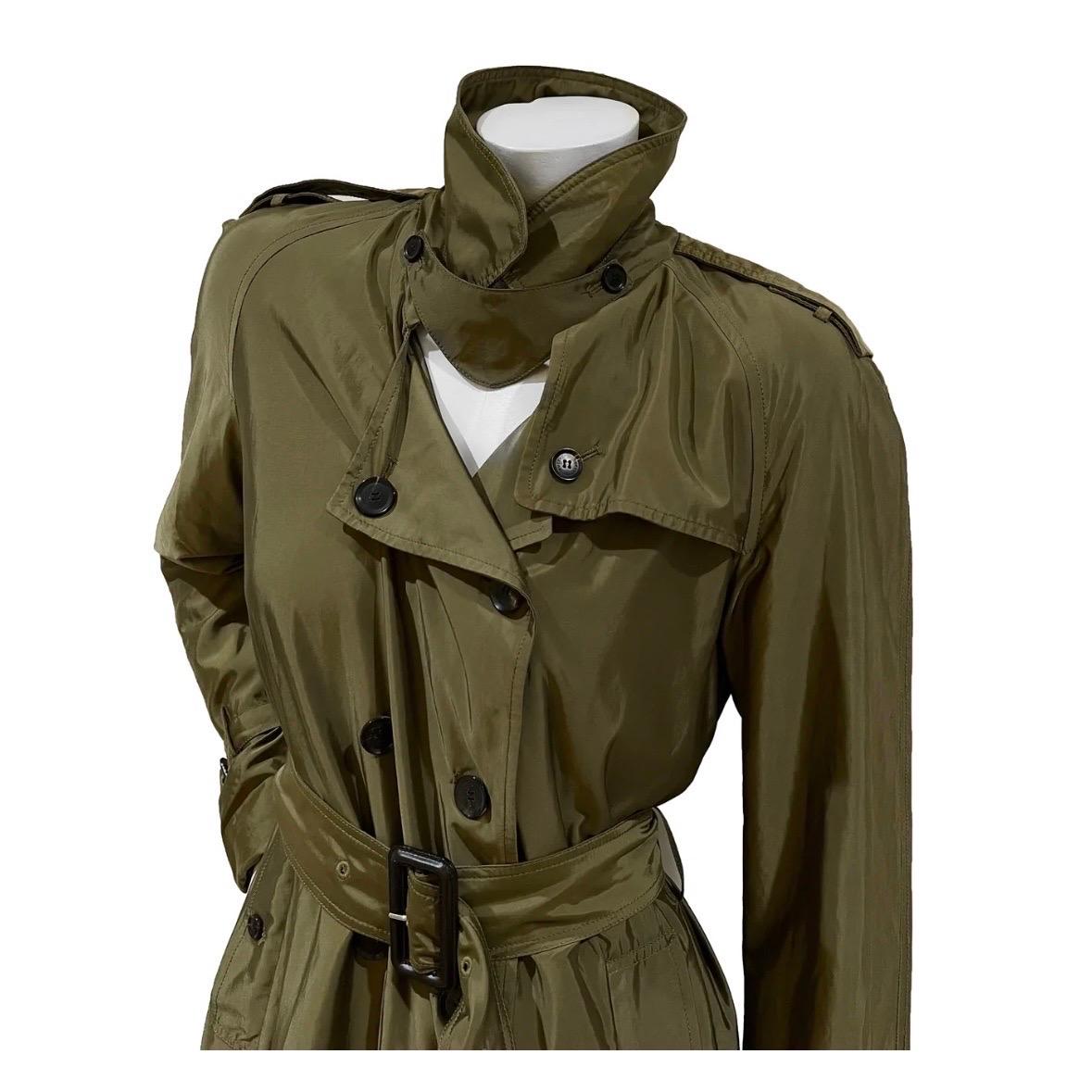 Green Nylon Trench Coat by Gucci
Resort 2011 Collection
Made in Italy
Green
Coat has adjustable belt with leather buckle detail
Trench coat style 
Button down and belt closure
Long sleeve
Neckline has removable fabric detail with button closure
Top