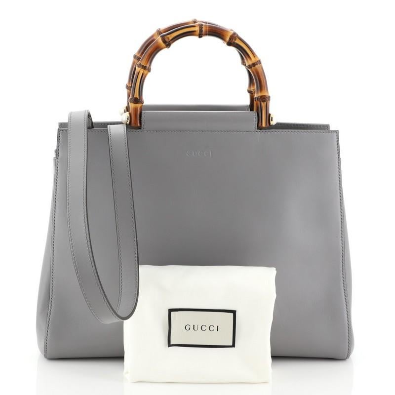 This Gucci Nymphaea Tote Leather Medium, crafted in gray leather, features a bamboo top handles with pearls and gold-tone hardware. Its snap closure opens to a neutral microfiber interior with zip and slip pockets. 

Estimated Retail Price: