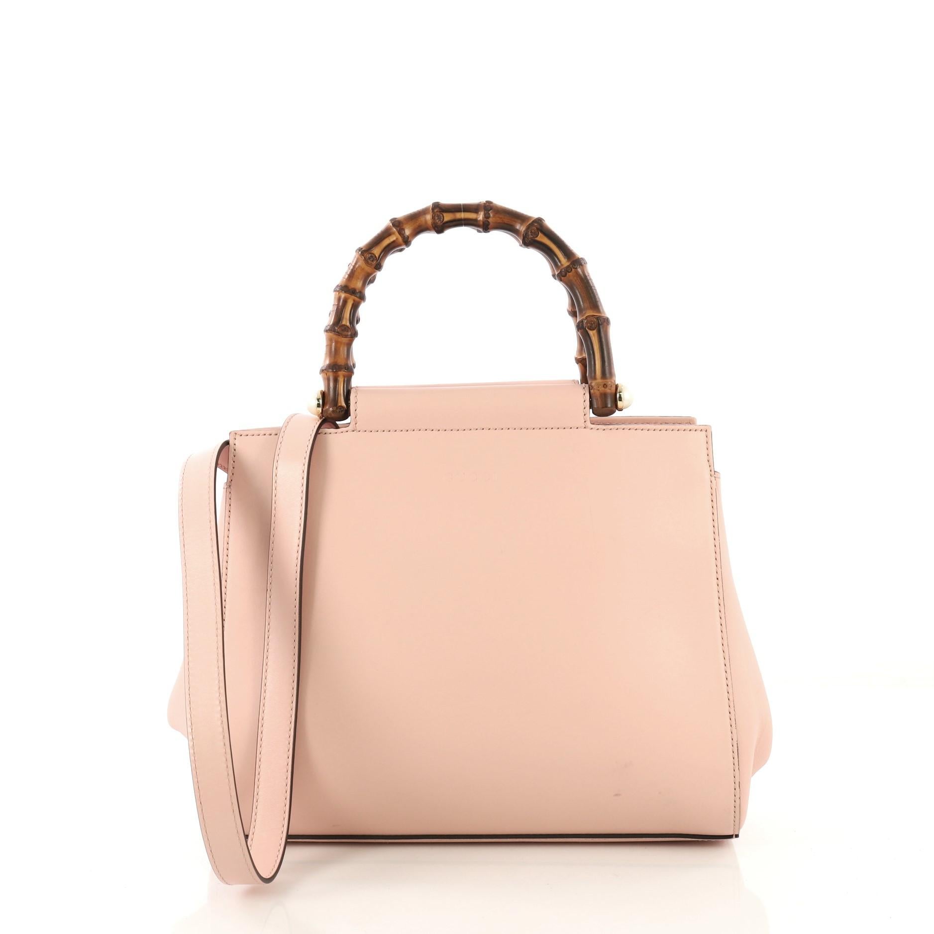 This Gucci Nymphaea Tote Leather Small, crafted in pink leather, features dual bamboo handles and gold-tone hardware. Its snap closure opens to a gray microfiber interior with zip and slip pockets.

Estimated Retail Price: $2,100
Condition: Good.