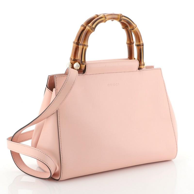 This Gucci Nymphaea Tote Leather Small, crafted in pink leather, features a leather shoulder strap, bamboo handle with pearls, and gold-tone hardware. Its snap closure opens to a gray microfiber interior with zip and slip pockets. 

Estimated Retail