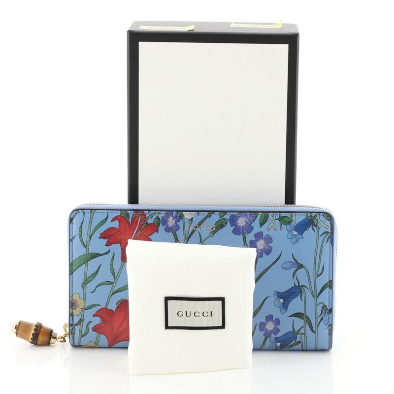 This Gucci Nymphaea Zip Around Wallet Flora Leather, crafted from blue printed leather, features gold-tone hardware. Its zip-around closure opens to a blue leather and brown fabric interior with multiple card slots and zip and slip pockets.