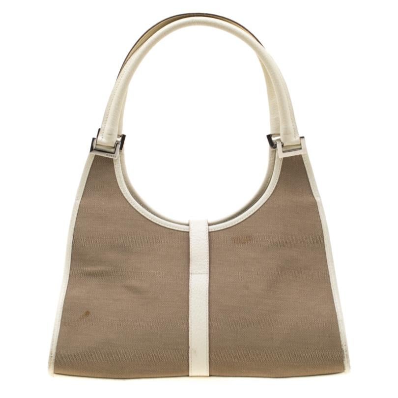You wouldn’t want to miss this lovely and classy Bardot bag by Gucci to counter an eye-catching look. Crafted with beige canvas and off-white leather details, it features dual top rolled handles along with a nylon-lined interior that houses a zipper