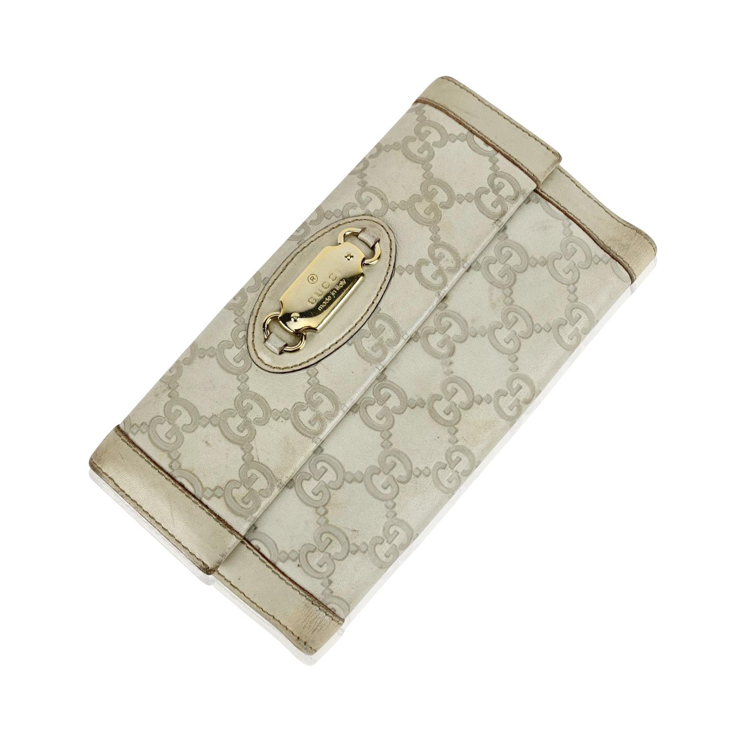 GUCCI off white continental 'Punch' wallet in off-white Guccissima leather. Flap with button closure on the front. Gold metal Gucci plate on the front. Fold over strap with button closure on the back. 7 credit card slots, 1 bill compartment and 2