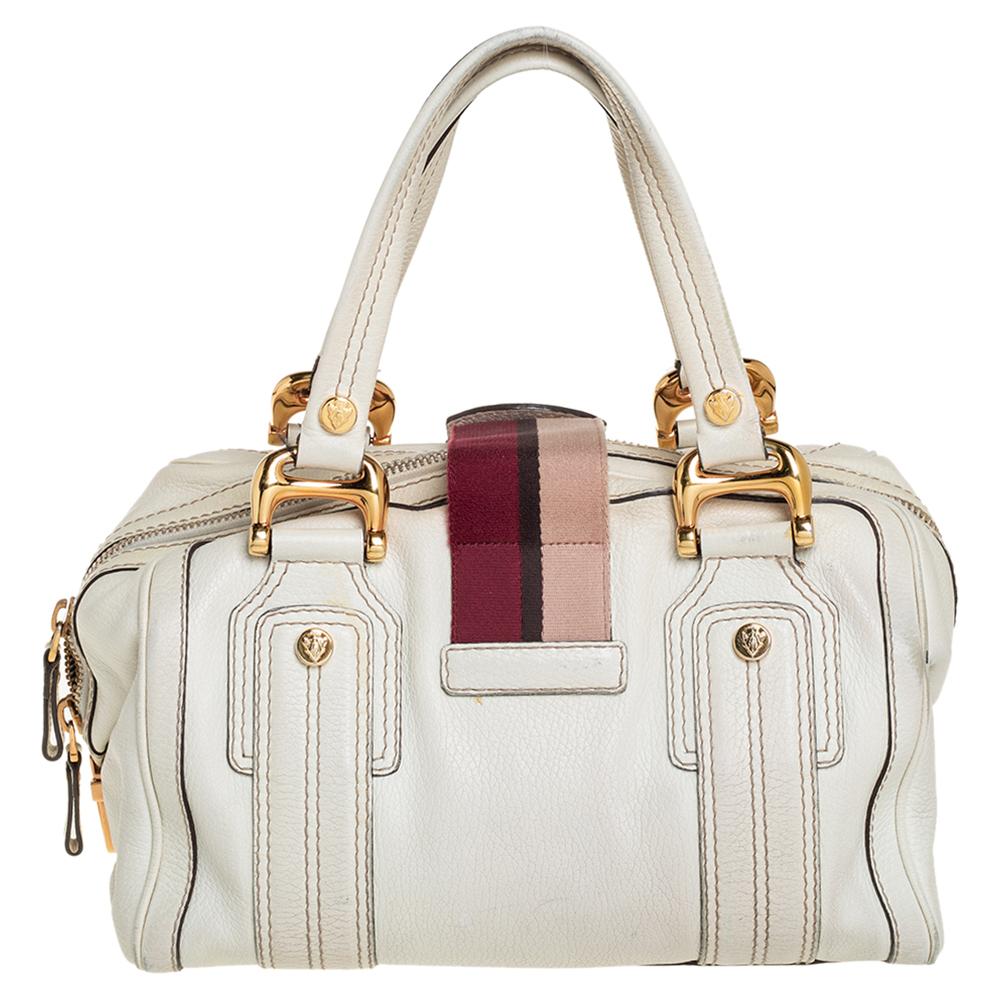 A truly posh and elegant piece to add to your collection. This Aviatrix Boston bag by Gucci is crafted from leather and styled with a Web flap that carries an emblem for a lock. It also has a top zip closure, two handles, protective metal feet, and