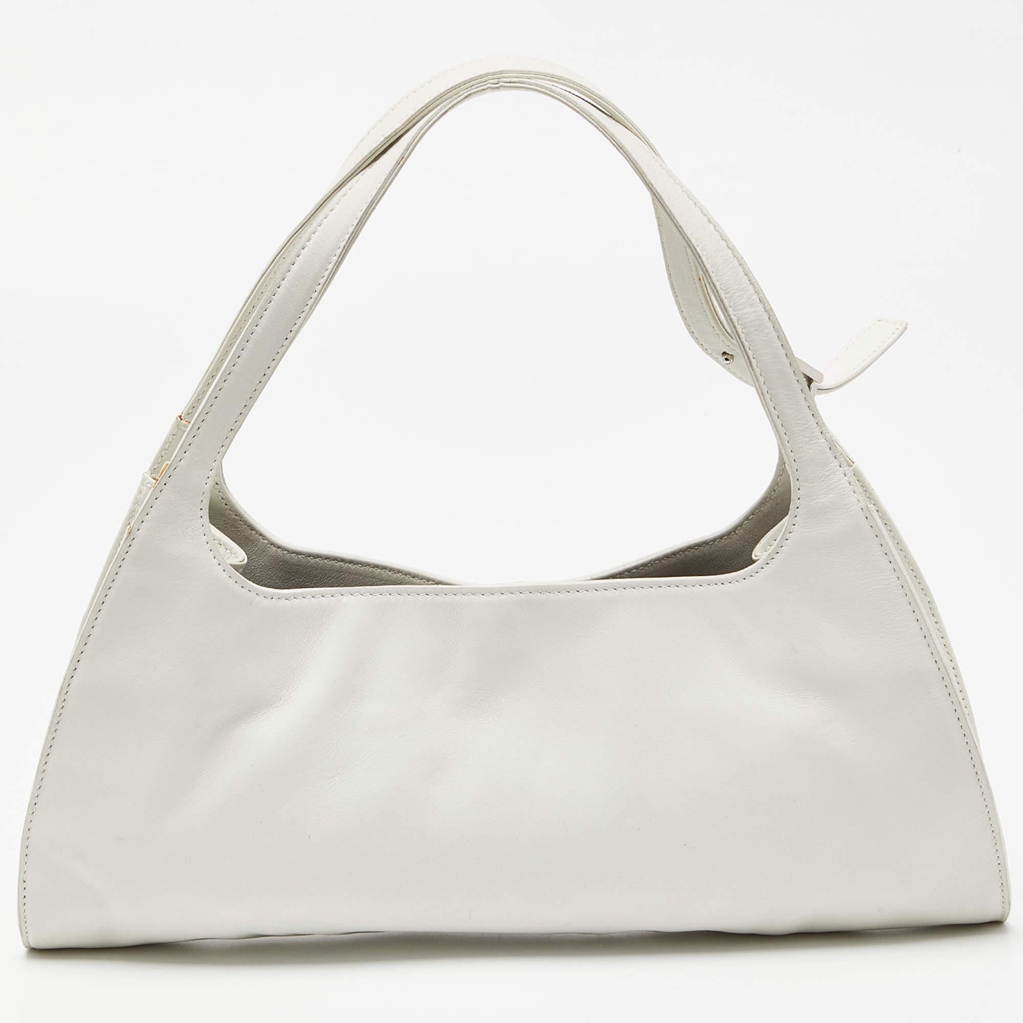 The simple silhouette and the use of leather for the exterior bring out the appeal of this Gucci hobo. It features flat handles, silver-tone hardware, and a lined interior.

