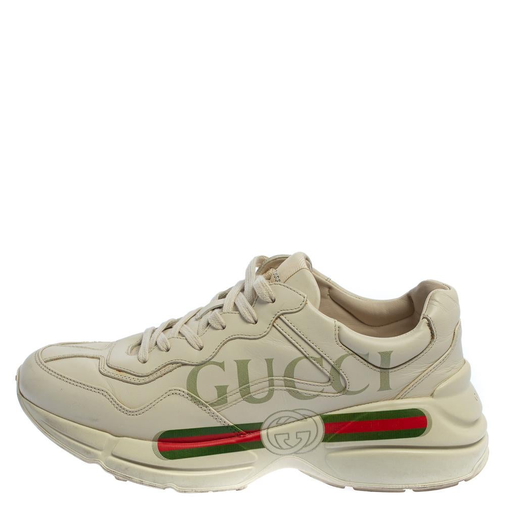 Project a stylish look every time you step out in these Rhyton sneakers from Gucci. They are crafted from off-white leather and styled with lace-ups on the vamps and brand logo and the signature Web print on the sides. They are equipped with