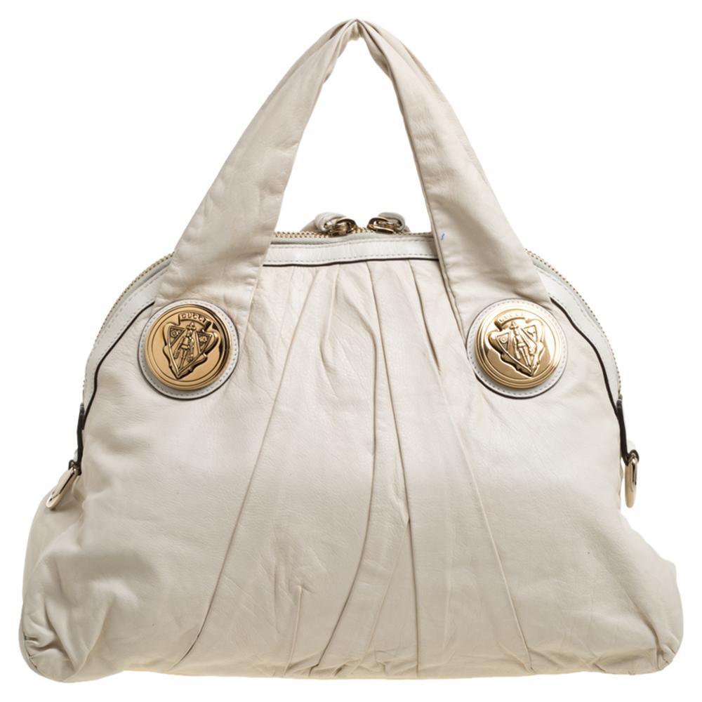 This Gucci hobo is built for everyday use. Crafted from leather, it has an off white exterior and two handles for you to easily parade it. The nylon insides are sized well and the hobo is complete with the signature emblems in gold-tone.

