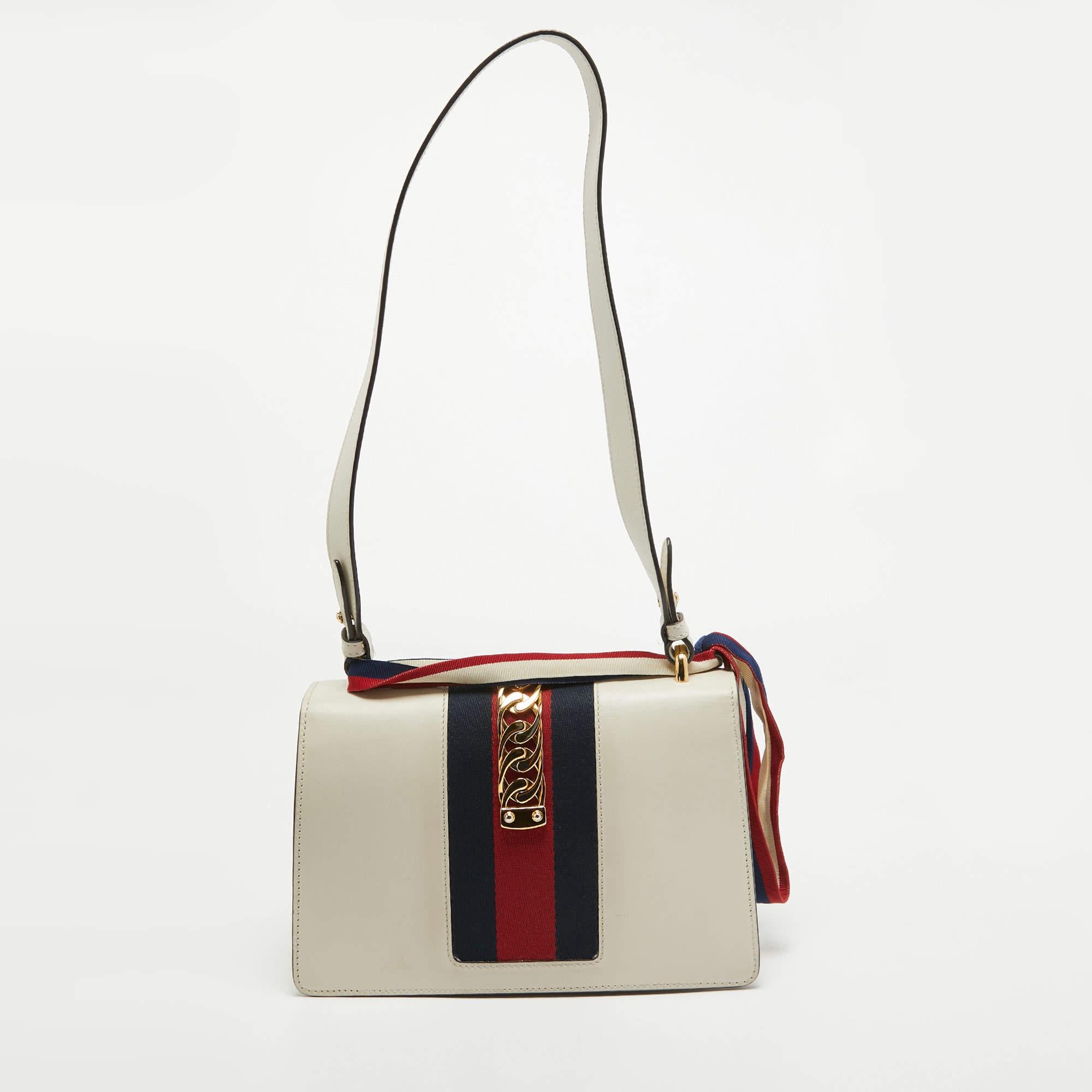 All the designs from Gucci, like this Sylvie bag, reflect a sense of innovation and tradition. Crafted from leather, it is admired for its alluring finish and structured silhouette. The chain shoulder strap makes it practical, and the signature