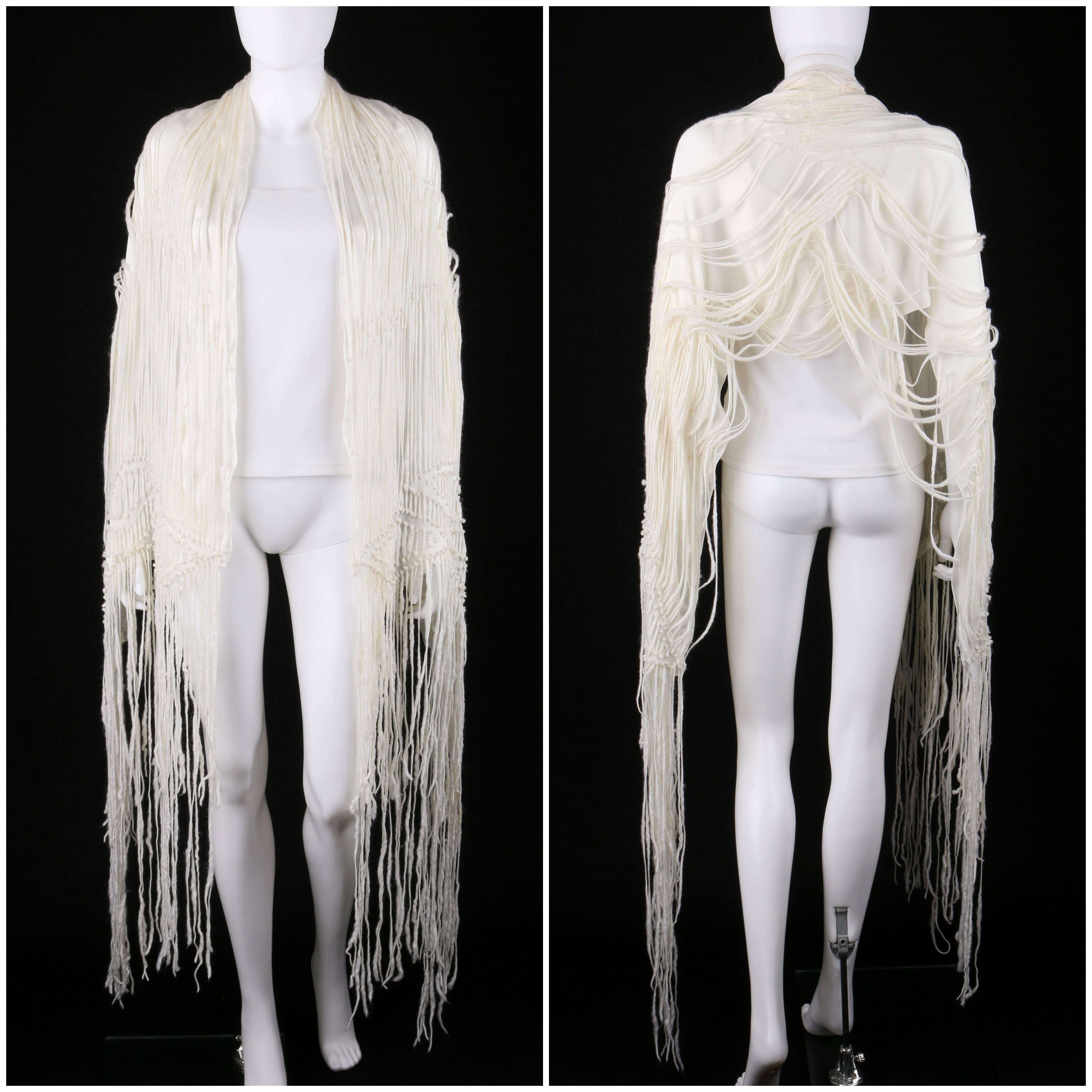 Gucci off white raw wool fringe and silk chiffon oblong scarf / wrap. Spun raw wool fringe top layer with knotted detail in diamond pattern and long fringe at both ends. Off white silk chiffon under layer. Oblong shape. Marked Fabric Content: 