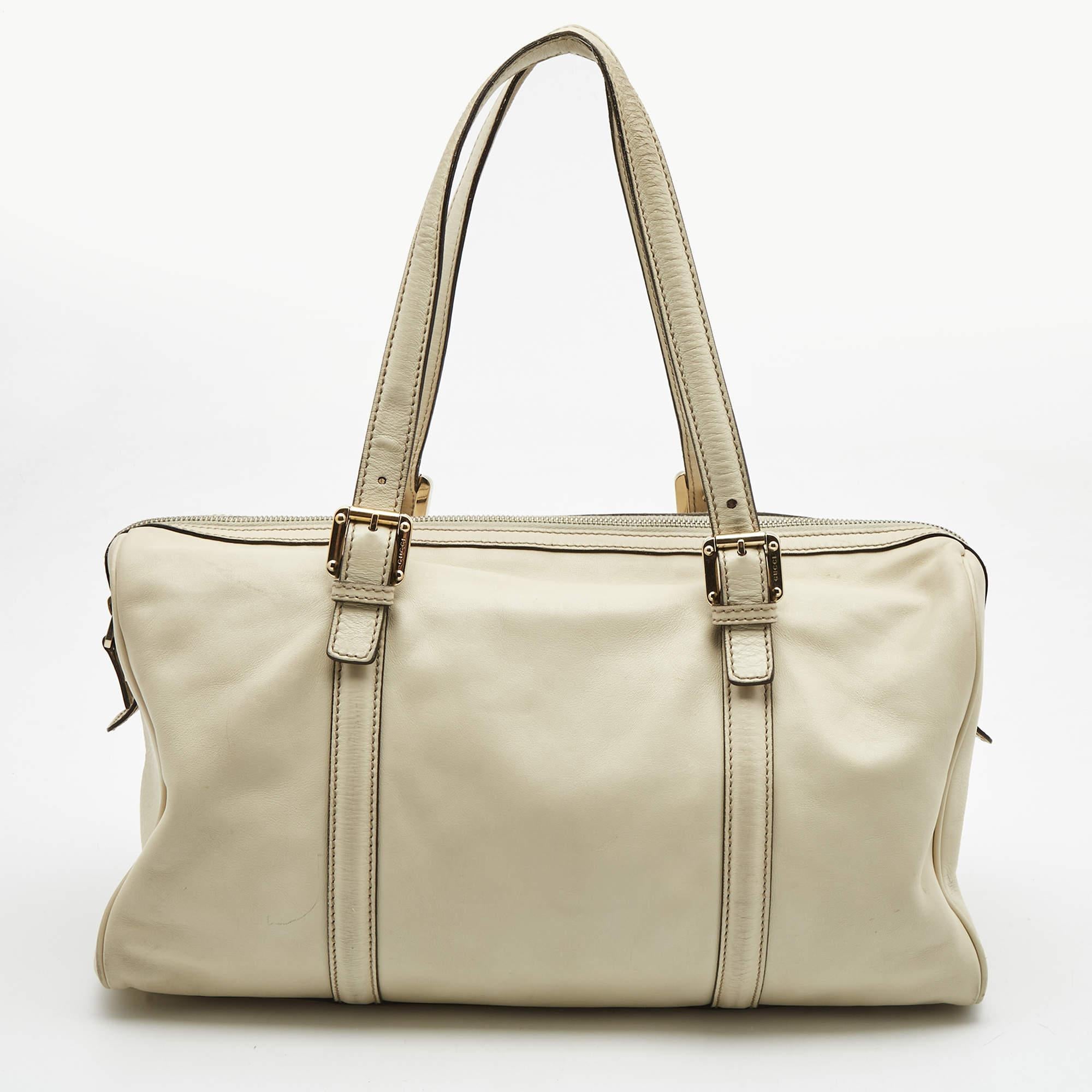 Simple details, high quality, and everyday convenience mark this Britt Boston by Gucci. The bag is made of off-white leather, and it features dual handles, a gold-tone GG logo on the front, and a spacious interior.

