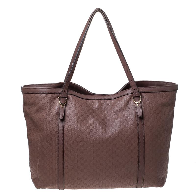Meticulously crafted from Microguccissima leather, this Gucci bag delights not only with its appeal but size as well. It is held by two top handles, detailed with gold-tone hardware and equipped with a spacious fabric interior. The grand shape, the