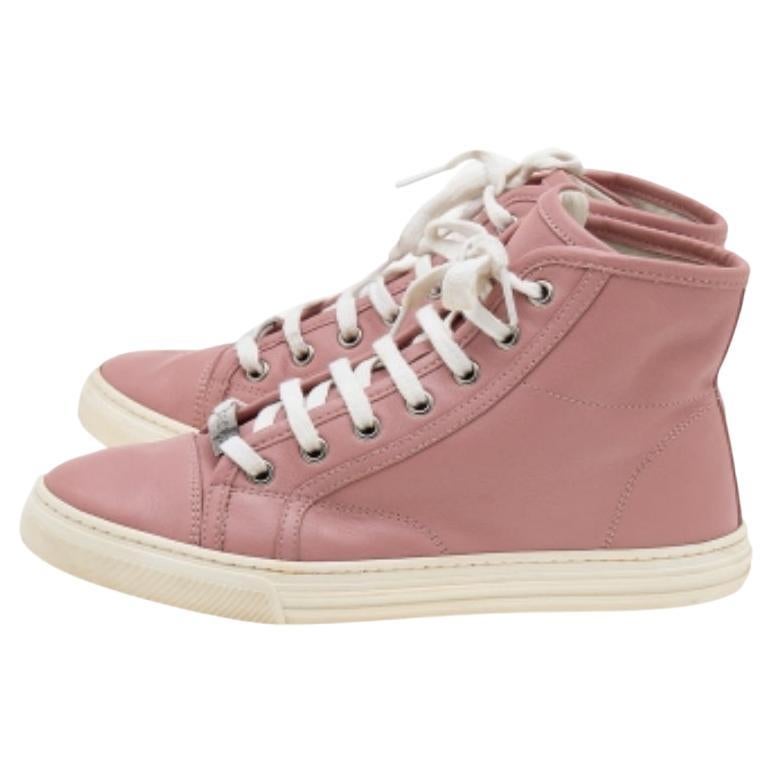 A stellar creation from the house of Gucci, these sneakers are a must-have for the summer season. They have been expertly designed from old rose leather. They are detailed with eyelets and feature a rounded toe. This high-top pair is sure to take