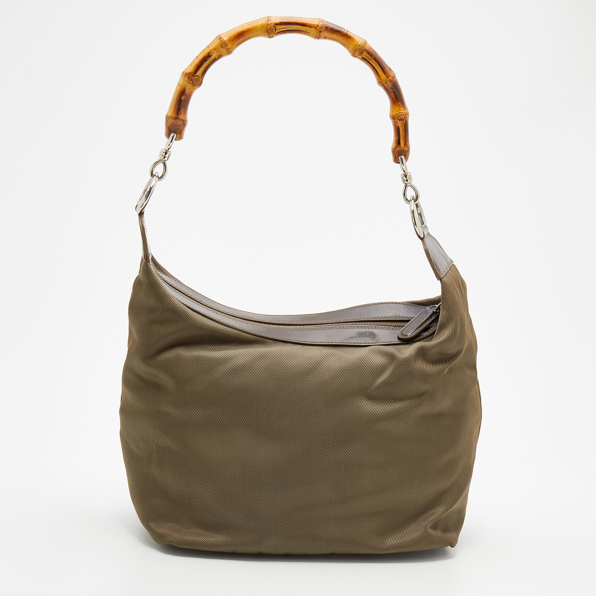 Spacious and captivating, this Peggy Bamboo hobo comes from the House of Gucci. It has been crafted from olive-green canvas and patent leather on the exterior. It features a single Bamboo-detailed handle, silver-tone hardware, and a fabric-lined