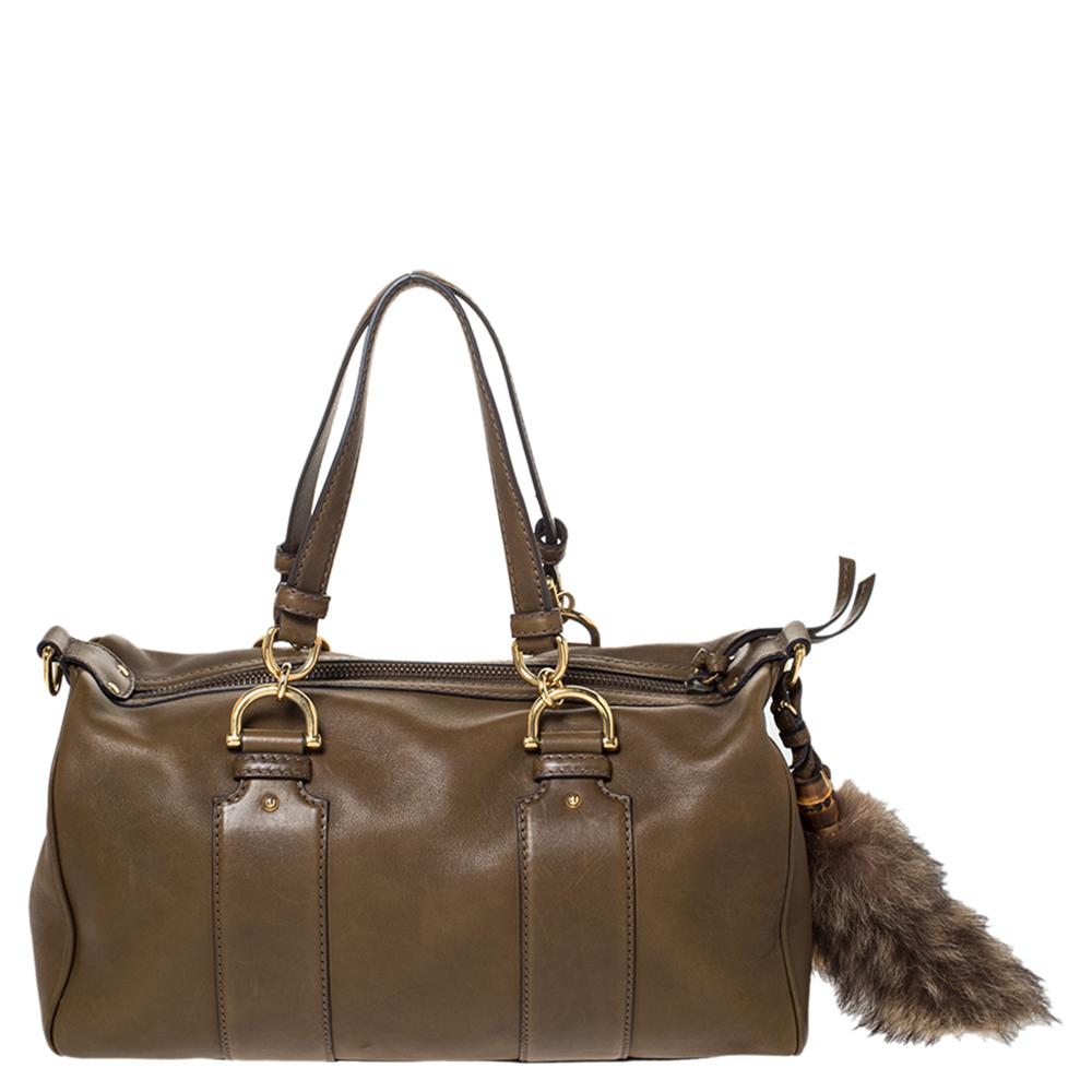 Look effortlessly chic with this olive green Gucci Smilla satchel. It features a smooth leather exterior, gold-tone hardware, two flat handles, a detachable and adjustable shoulder strap and a Gucci label on the front. It has a bamboo and fur tails