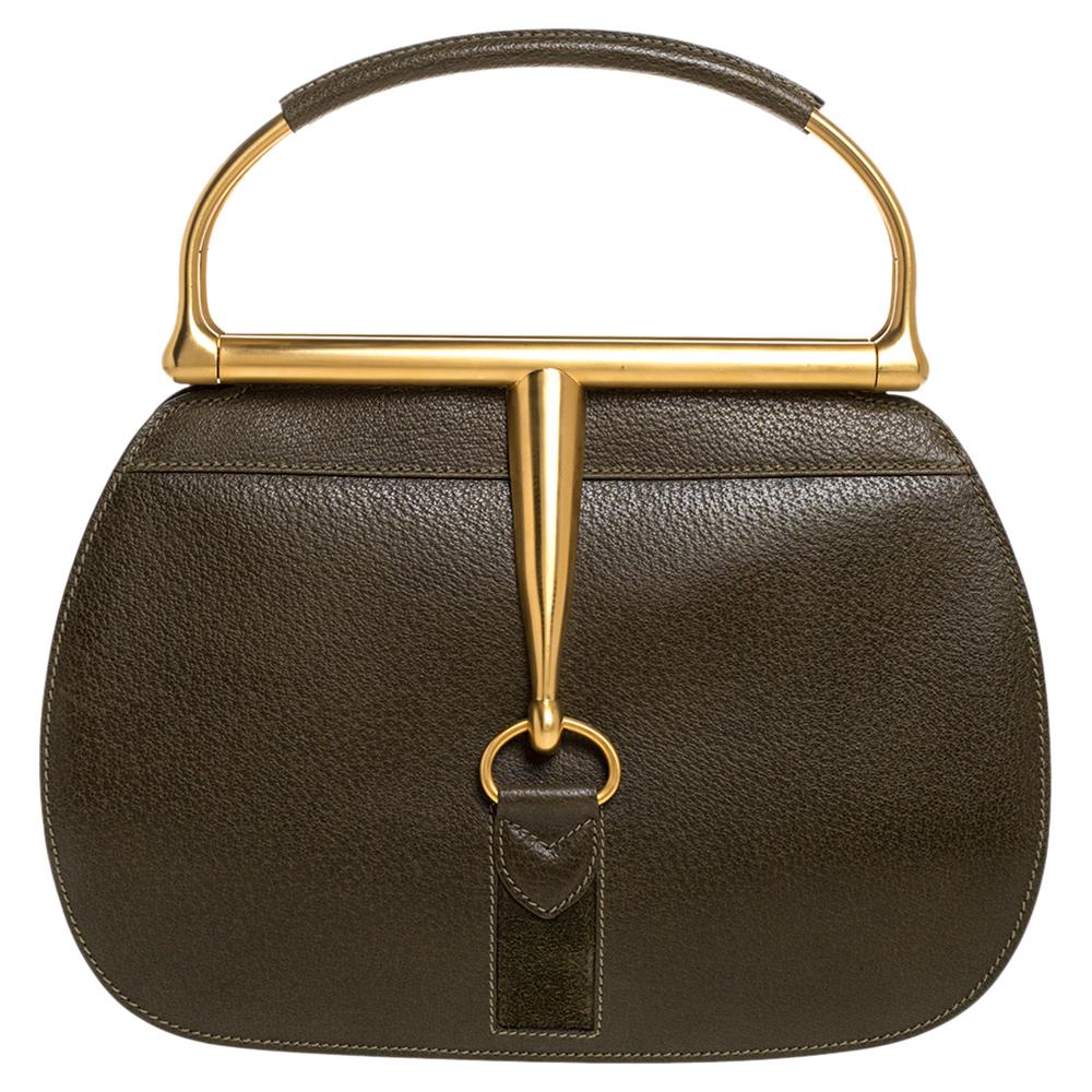 This vintage piece manifests Gucci's take on the doctor's bag. It features the distinctive Horsebit accent on the front as well as back for a signature look. It's polished green leather exterior is framed beautifully with a gold-tone top and metal
