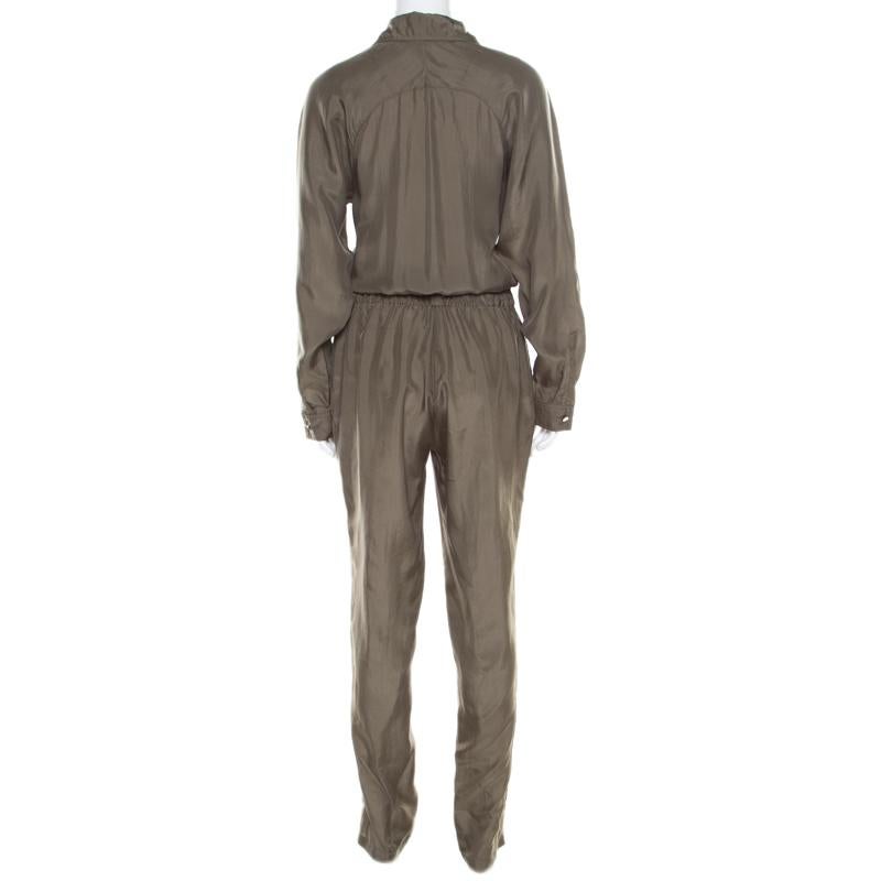 Made from silk, this olive green jumpsuit by Gucci has been styled with long sleeves, pockets, and a cinched waist. It is completed with a zip fastening and the brand label. Style this jumpsuit with strappy gold stilettos for a high-fashion