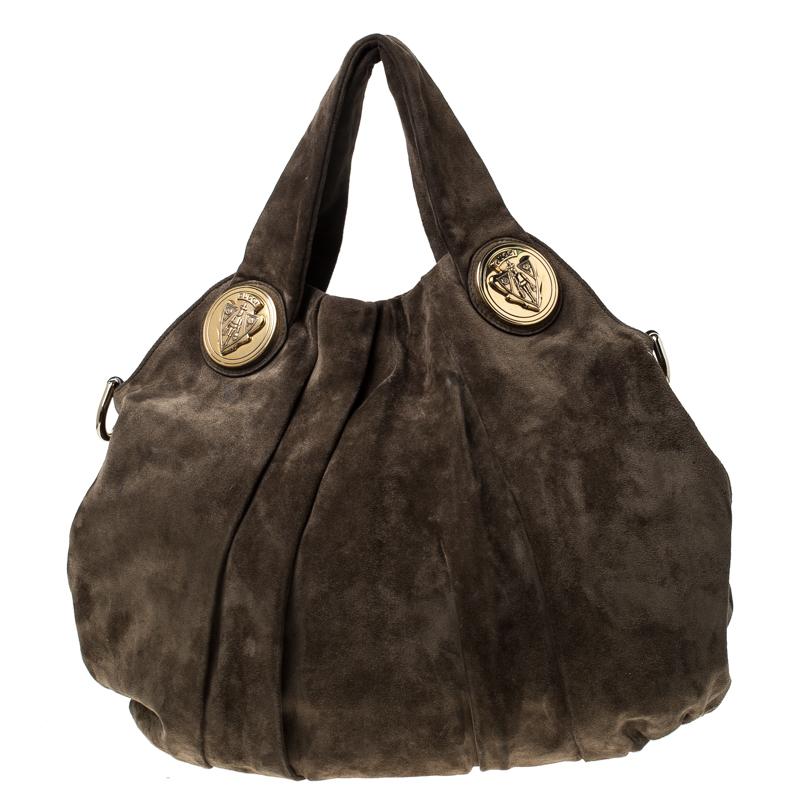 This Gucci hobo is built for everyday use. Crafted from suede, it has an olive green exterior and two handles for you to easily parade it. The nylon insides are sized well and the hobo is complete with the signature emblems.

Includes: Original