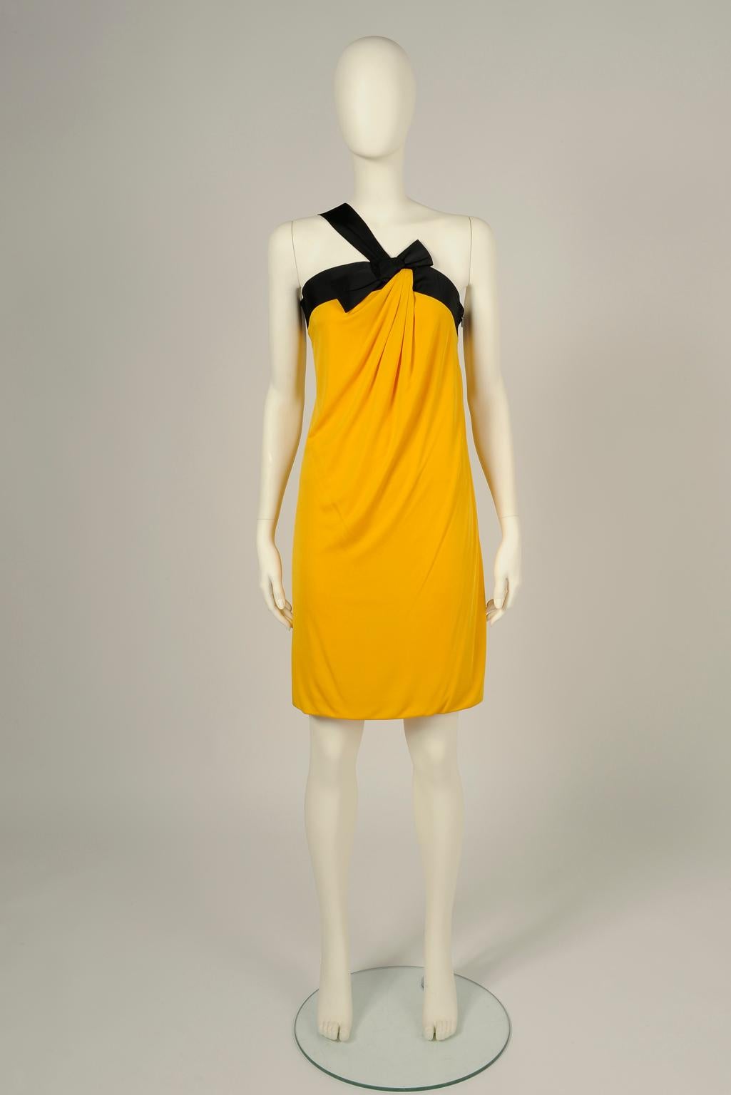 In a vibrant sunny yellow shade that really stands out, this Gucci cocktail dress is made from a double layer of soft silk jersey artfully draped, folded like an envelope, which comfortably hugs your frame. Contrasted black taffeta sweeping