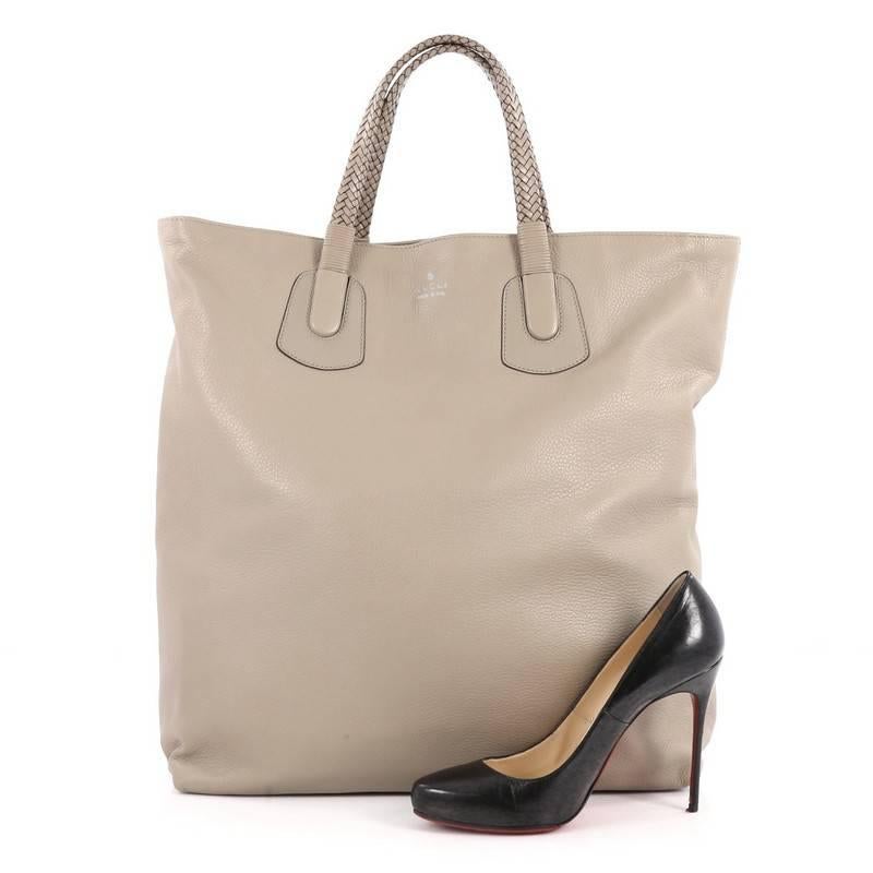 This authentic Gucci Open Tote Soft Deer Tall is perfect for any casual or sophisticated outfit for the style-conscious professional. Crafted from taupe soft deerskin leather, this elegant tote features dual braided handles, side snap buttons, and