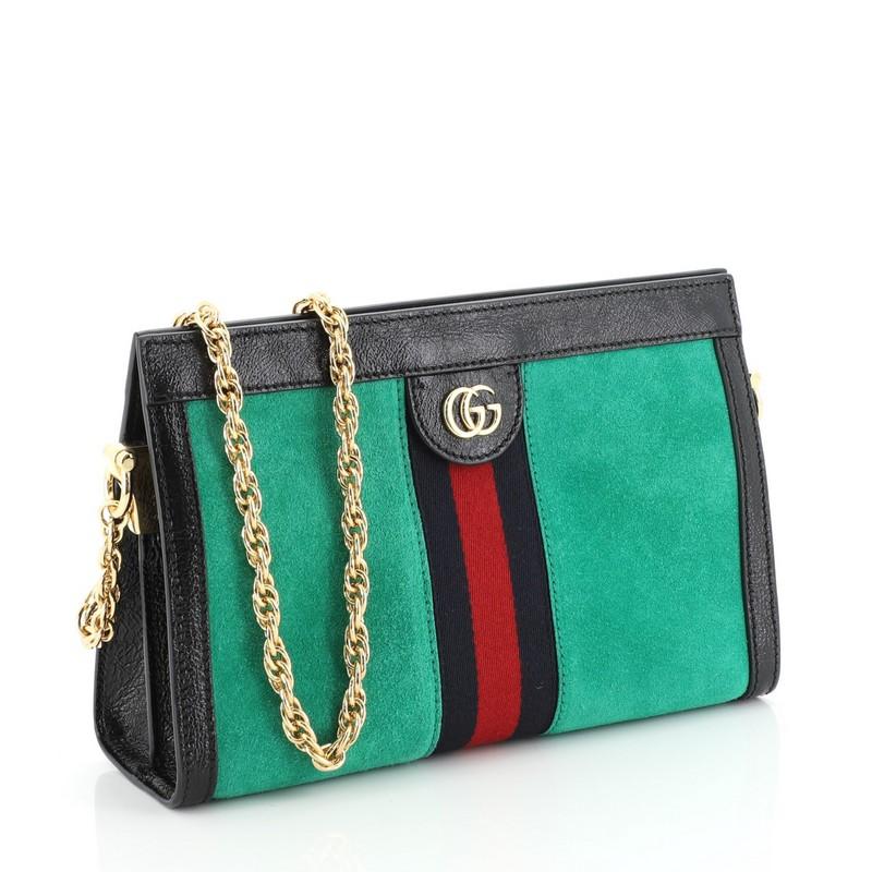 This Gucci Ophidia Chain Shoulder Bag Suede Small, crafted in green suede, features a web stripe detail, chain link shoulder strap, leather trim, Gucci logo, and gold-tone hardware. Its hidden magnetic snaps closure opens to a blue satin interior