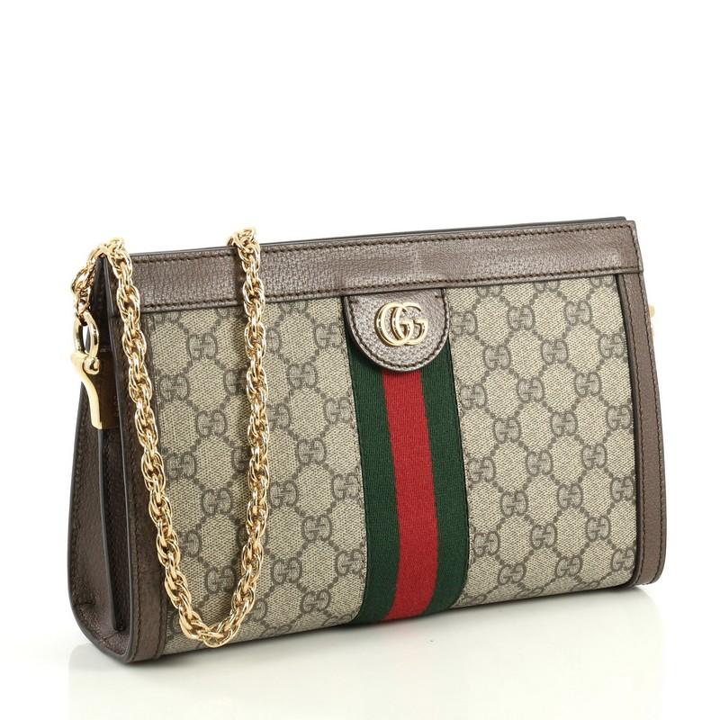 This Gucci Ophidia Chain Shoulder Bag GG Coated Canvas Small, crafted in brown GG coated canvas, features inlaid web stripe detail, chain link shoulder strap, and gold-tone hardware. Its hidden magnetic snaps closure opens to a blue satin interior