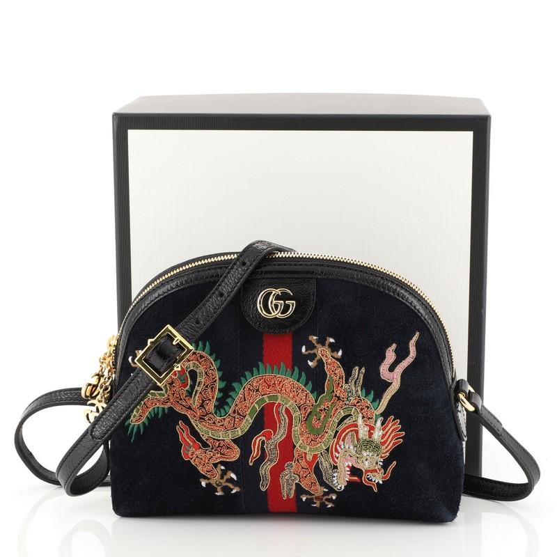This Gucci Ophidia Dome Shoulder Bag Embroidered Suede Small, crafted in blue suede, features inlaid web stripe detail, leather shoulder strap, and gold-tone hardware. Its zip closure opens to a blue satin interior with side slip pockets.