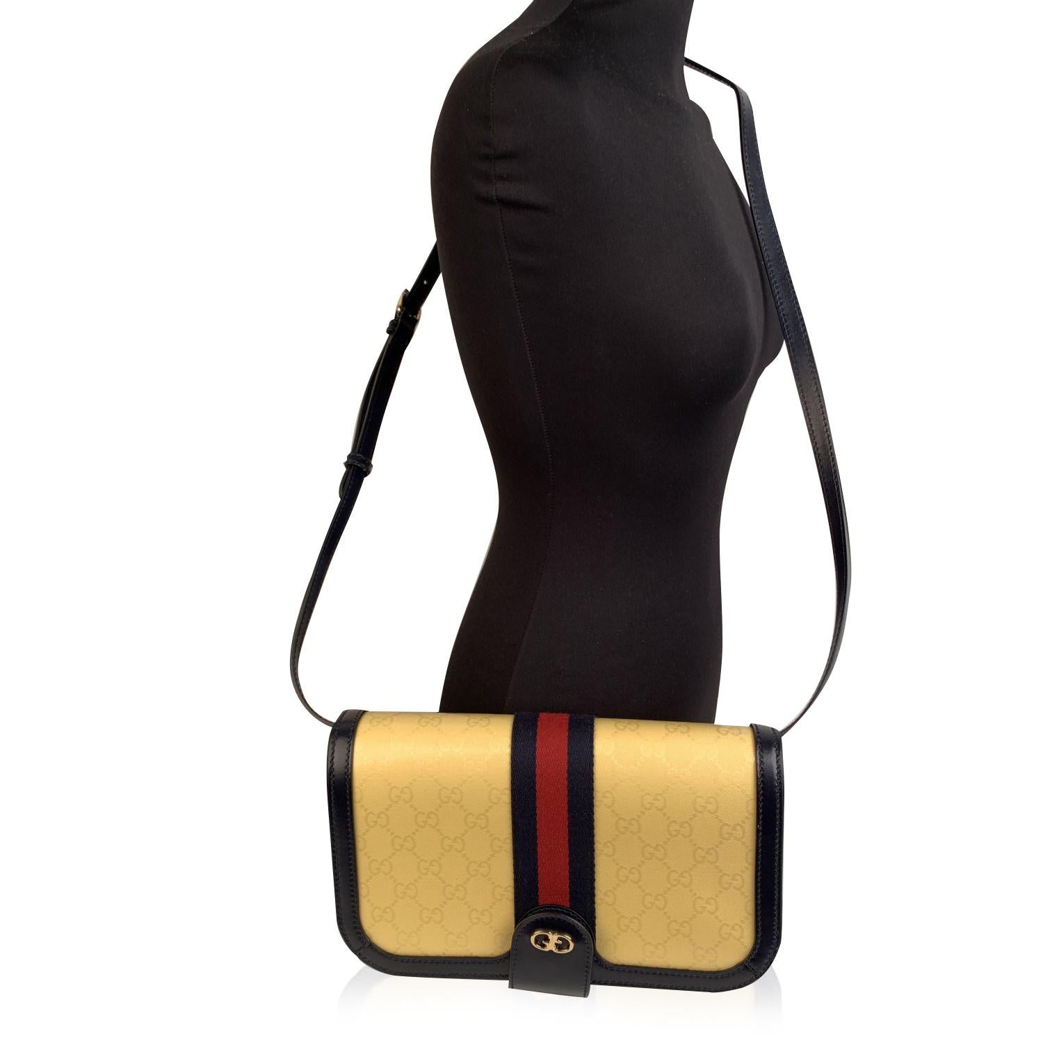 Beautiful 'Ophidia Compartment GG Imprime' Messenger Bag by Gucci, crafted in yellow GG monogram canvas with navy blue genuine leather trim. It features blue/red/blue signature web around the bag and gold metal GG - GUCCI logo on the front. Flap