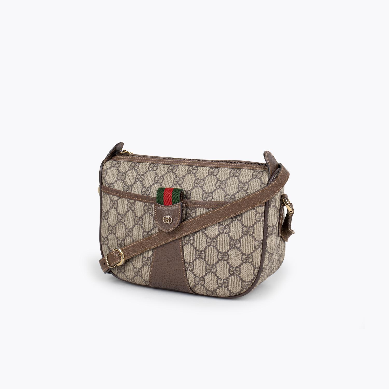 Beige and brown GG Plus coated canvas Gucci Ophidia crossbody bag with

- Gold-tone hardware
- Single flat shoulder strap
- Green and red striped canvas lining
- Dual pockets at interior walls; one with zip closure and zip closure at top

Overall