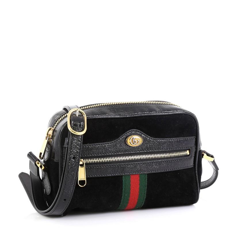 This Gucci Ophidia Shoulder Bag Suede Mini, crafted in black suede, features adjustable leather strap, exterior front zip pocket, Gucci web design, and gold-tone hardware. Its zip closure opens to a neutral microfiber interior with slip pocket.