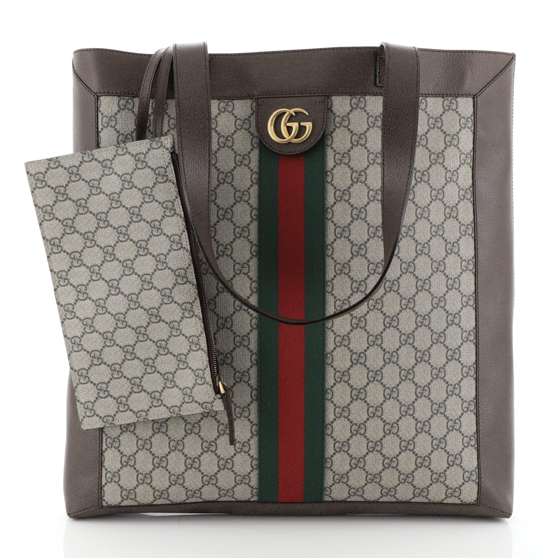This Gucci Ophidia Soft Open Tote GG Coated Canvas Large, crafted in brown GG coated canvas, features dual leather shoulder straps, Gucci web design, and aged gold-tone hardware. It opens to a neutral microfiber interior. 

Estimated Retail Price: