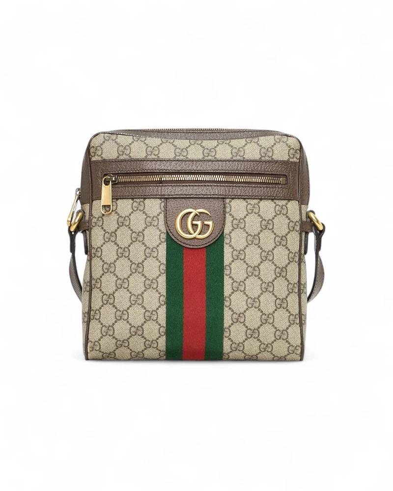 Borsa firmata Gucci, linea Ophidia, realizzata in tela nella classica fantasia GG Supreme con inserti in pelle marrone con hardware dorato. Dotata di una chiusura superiore a zip, internamente rivestita in tela beige con comoda tasca, la borsa è