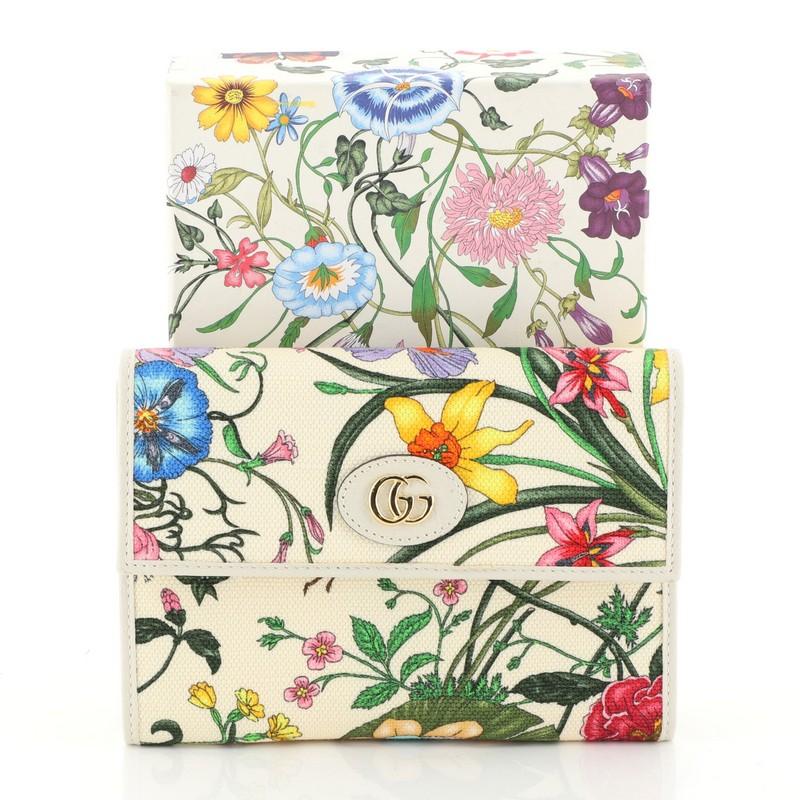 This Gucci Ophidia Wallet Flora Canvas Small, crafted in neutral printed leather, features GG logo at front, leather trim and gold-tone hardware. Its flap opens to a purple nylon interior with two compartments and slip pockets. 

Condition: Great.