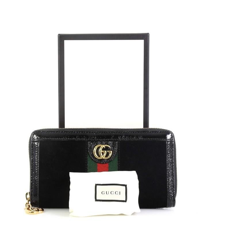 This Gucci Ophidia Zip Around Wallet Suede, crafted in black suede, features red and green web detail, GG logo and gold-tone hardware. Its zip closure opens to a black leather and fabric interior with multiple card slots and zip pocket. 

Estimated