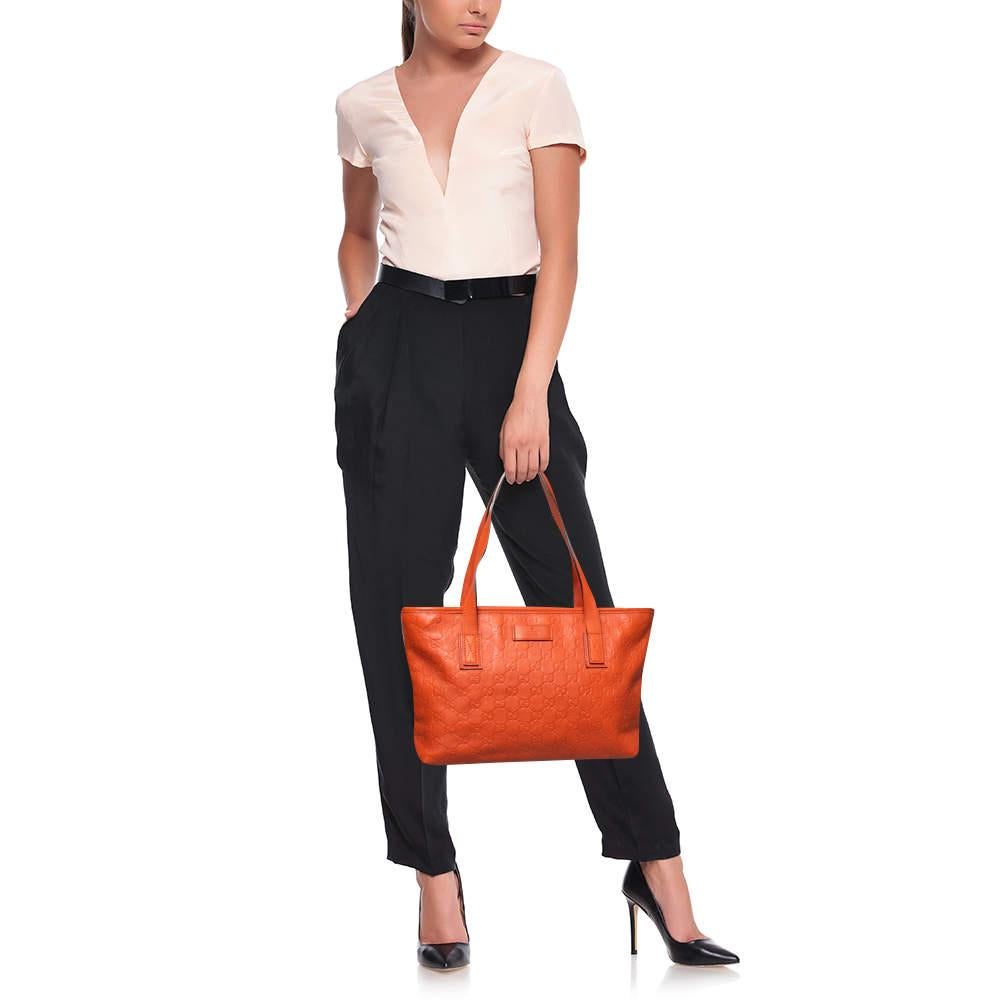 Add a bright pop of color to your ensemble with this orange shopper tote from Gucci. Crafted from Guccissima leather, it has dual handles, gold-tone hardware, and a spacious fabric interior that can house your essential items with ease. Style it