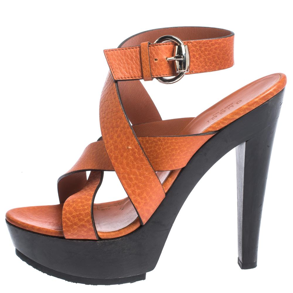 Complete an effortless look with these well-made Gucci orange sandals. They feature open toes, cross straps and buckle fastening. They are made from leather and set on platforms and 14 cm high heels.

Includes
Original Dustbag