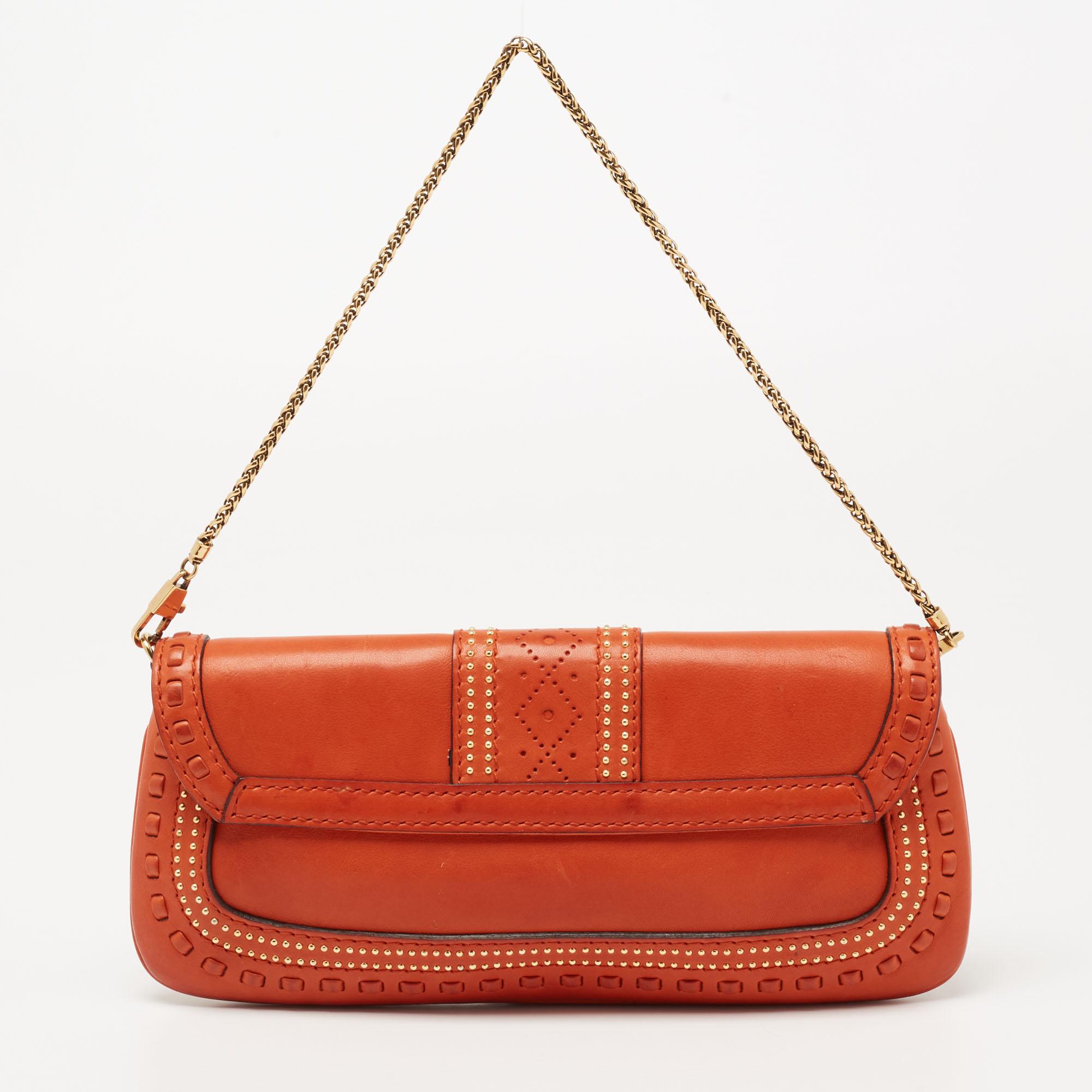 
This Gucci bag is a timeless piece that can last you season after season. This bag is made of leather and sized to house all the things you need. It has an orange shade, gold-tone metal detailing, a shoulder chain, and Alcantara lining.

