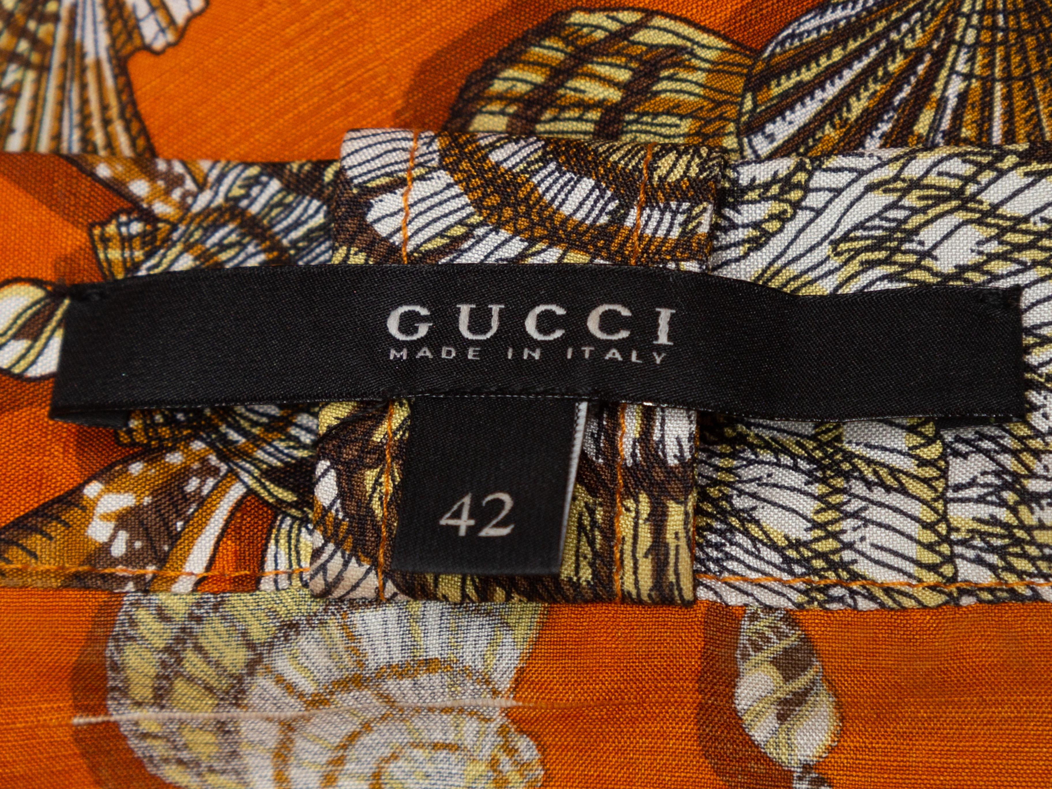 Product details: Orange and multicolor silk seashell print dress by Gucci. Short puff sleeves. V-neck featuring pussybow accent. Designer size 42. 36