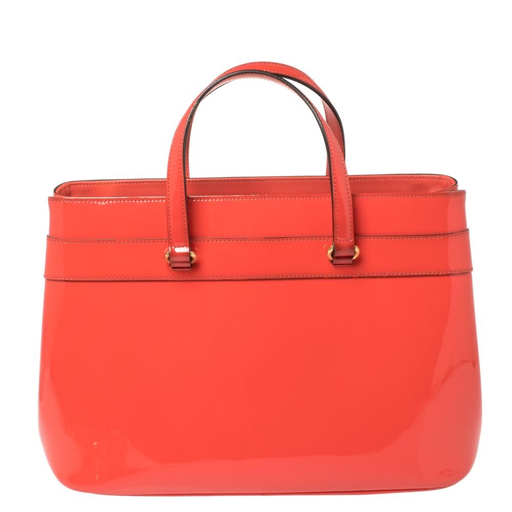This Bright Bit bag from Gucci proves that style can come in simple things too. Crafted from patent leather, this vibrant orange-hued bag features a fabric-lined interior, two top handles, and a long detachable shoulder strap. It is equipped with