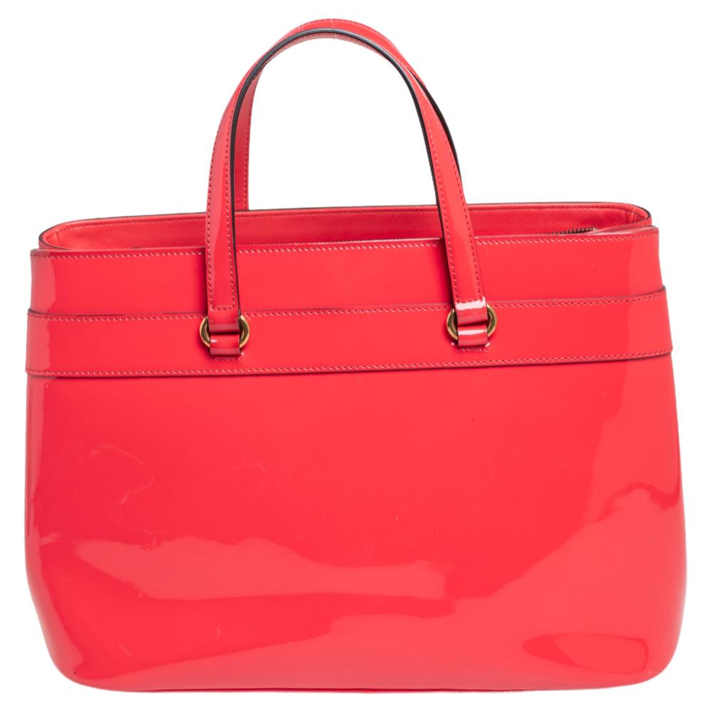 This Bright Bit bag from Gucci brings a vibrant style. Crafted from patent leather, this lovely orange bag features a fabric-lined interior, two top handles, and a long detachable shoulder strap. It is enhanced with gold-tone hardware and the