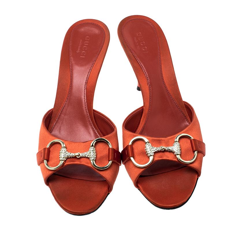 Finesse and poise will all come naturally to you when you step out in this pair of Horsebit slides from Gucci. Crafted from orange satin, the slides have been styled with Horsebit details embedded with crystals and 8.5 cm heels. The insoles have