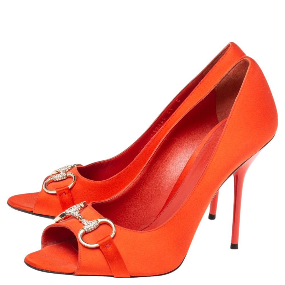 Walk with grace and confidence in these peep-toe pumps by Gucci. Styled in a vibrant orange shade, with dazzling Horsebit details embellished with crystals, leather insoles, and 10.5 cm heels, these satin pumps will never fail to lift your outfits.