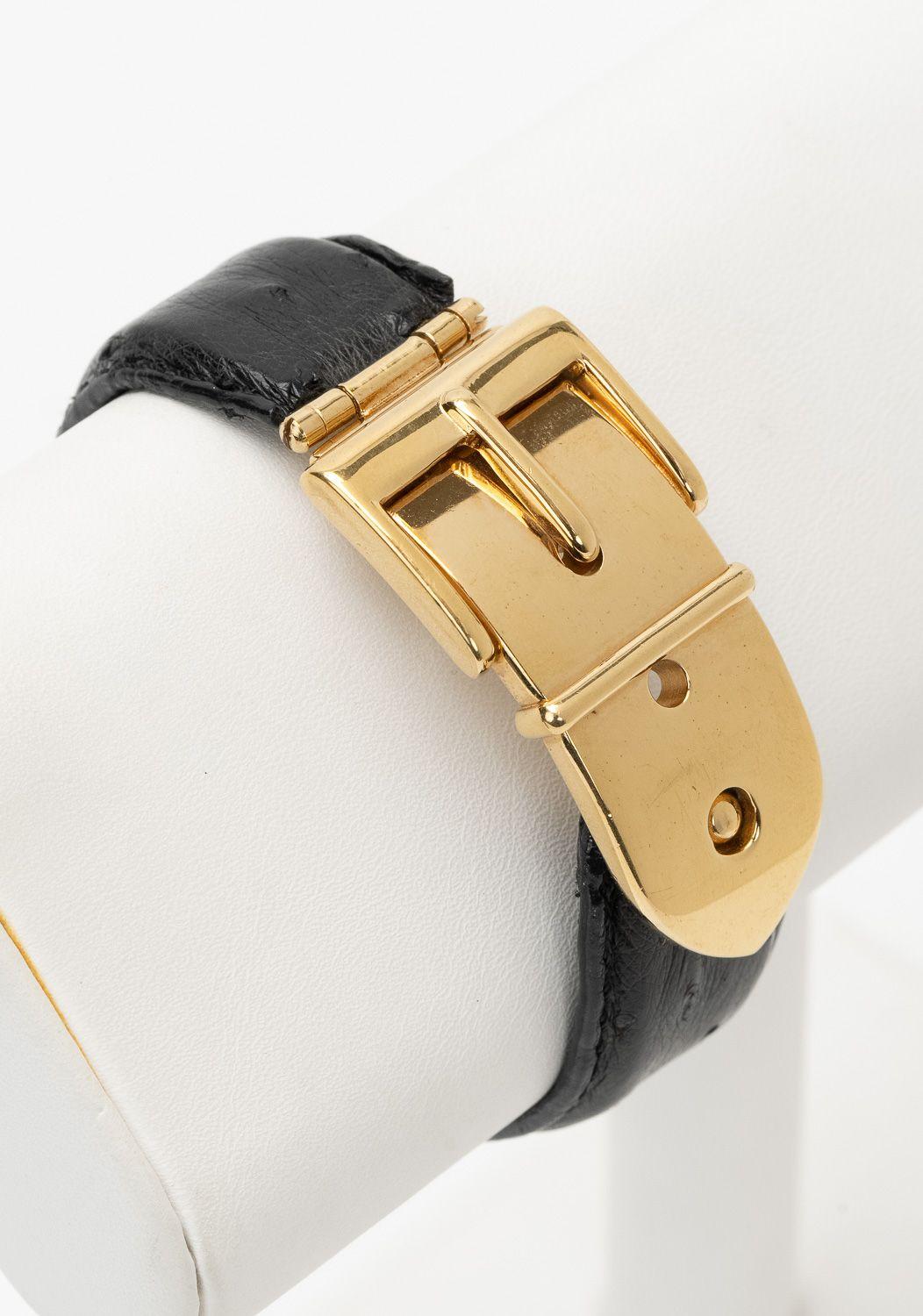 Gucci black ostrich leather cuff bracelet with gold-plated buckle hinge clasp. Clasp closure. Interior, 7.25