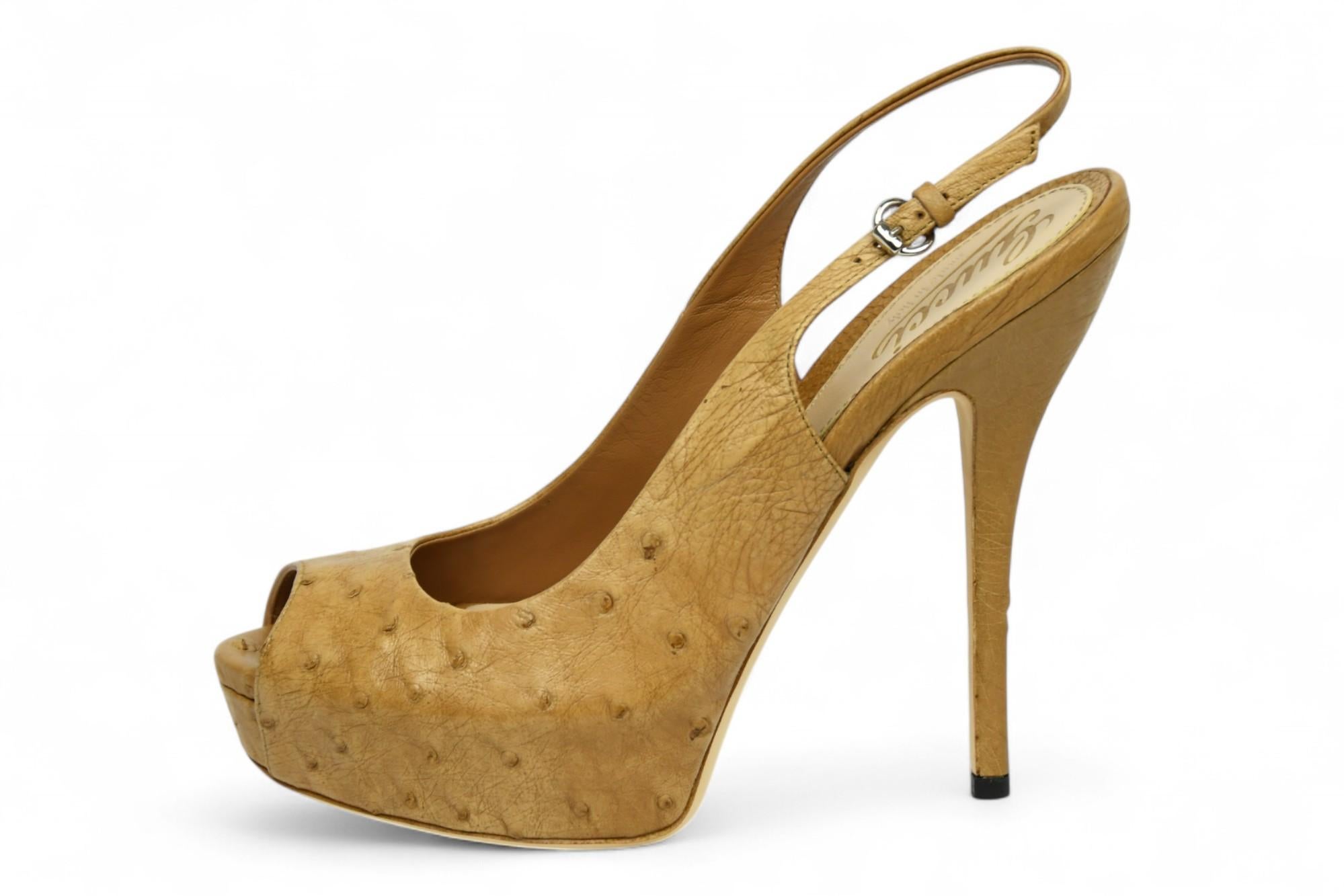 Realizzati in vera pelle di struzzo, questi tacchi slingback di Gucci emanano un lusso esotico con una silhouette scultorea e all'avanguardia. La calda tomaia in tonalità banana presenta una punta arrotondata, un sottile tacco a spillo e un