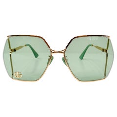 Gafas de sol Gucci oversize verdes con montura metálica dorada y logotipo GG