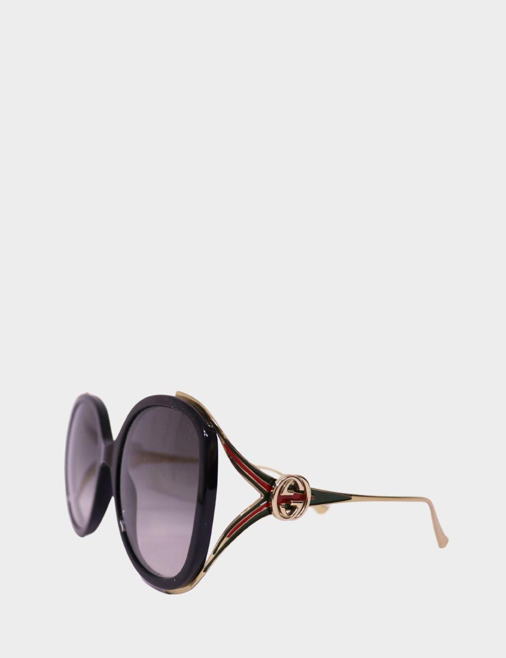 Step into bold vintage glamour with these statement Gucci round-frame sunglasses. Featuring oversized black lenses framed in glossy acetate, the design is accentuated by the signature Gucci green and red web stripe on the arms and the iconic