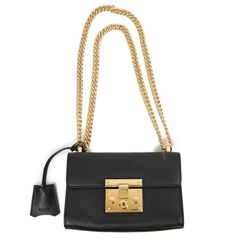 Season after season, the Padlock bag from GUCCI has new designs, sizes, colors or leathers. It has became an iconic bag for the brand. This one is in smooth black leather with gilt metal jewelry. It is lined in camel suede-style leather and
