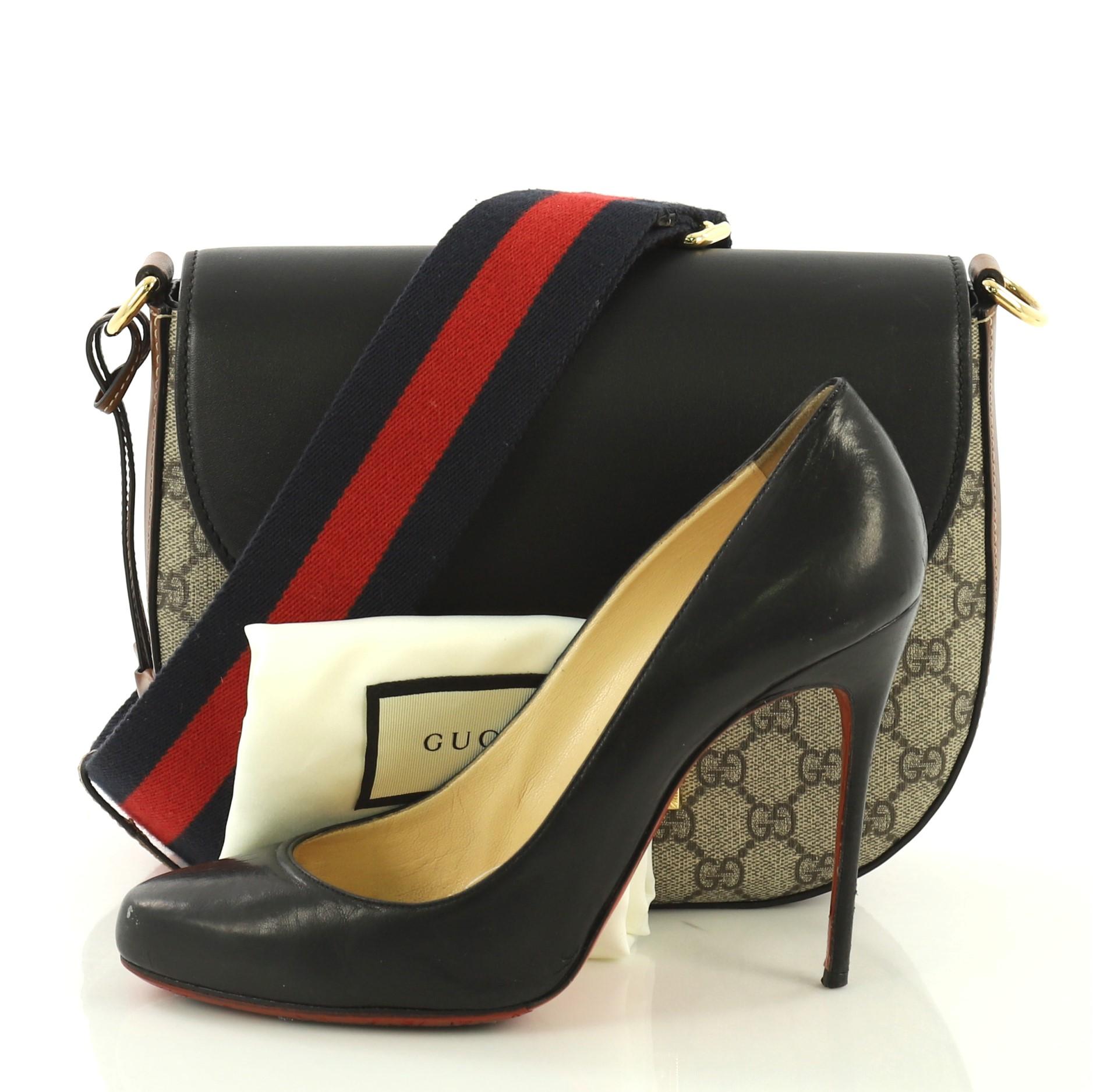 This Gucci Padlock Saddle Shoulder Bag GG Coated Canvas and Leather Medium, crafted from brown GG coated canvas with black and brown leather, features detachable adjustable web strap, front flap and gold-tone hardware. Its push clasp closure opens